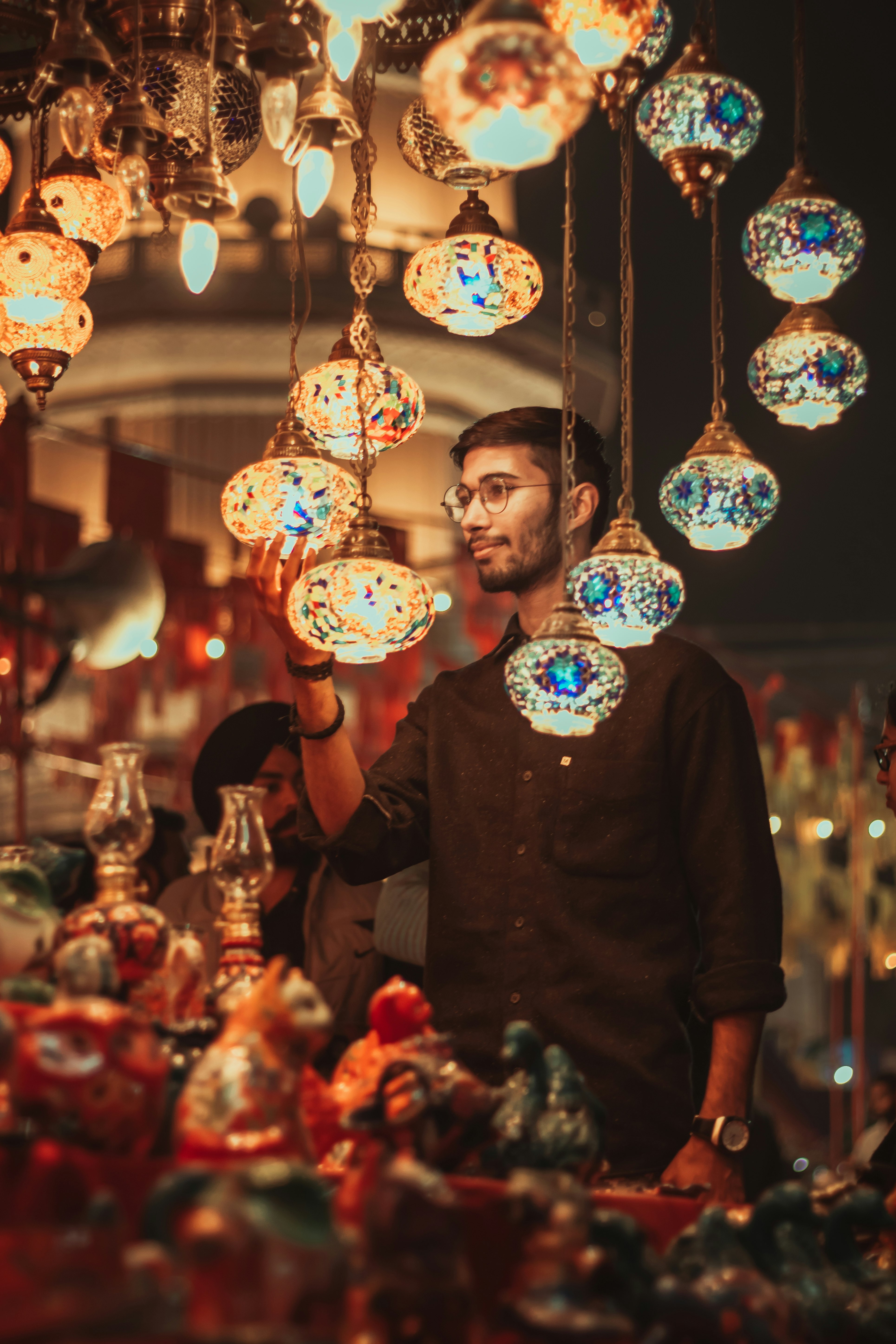 man in brown crew neck t-shirt standing beside white blue and yellow floral round balloons